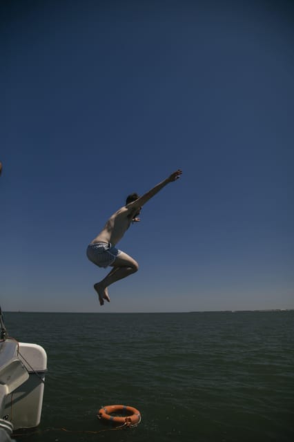 Lisbon: Catamaran Boat Party with Music, Open Bar & Dives - Belém Tower from the water